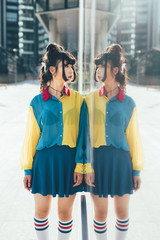 Young beautiful nonconformist asiatic woman posing outdoor in the city, looking at herself in the...