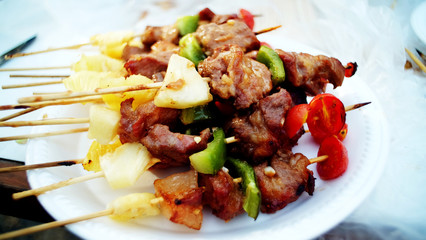 Close up barbecue grills at barbecue party on white dish at countryside in holiday.BBQ with pineapples.