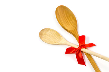 Wooden spoon with red bow in gift concept on white background.