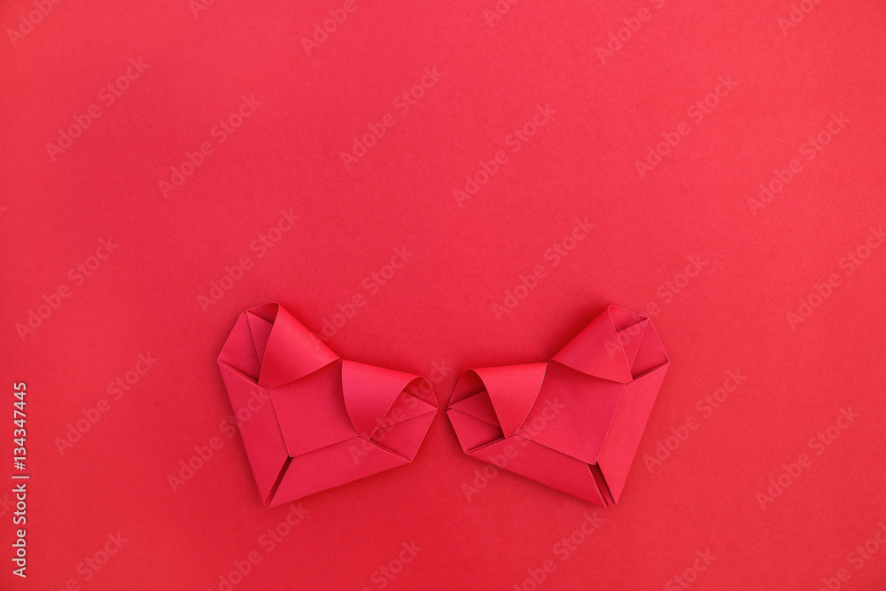 Poster two folding red paper hearts on red for pattern and background
