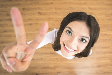 The woman show two finger to the camera. View from above