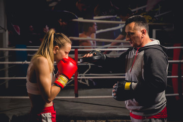 Women boxer hits mitts held by her trainer
