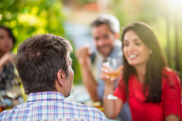 Back view, man lunching with friends on a terrace table