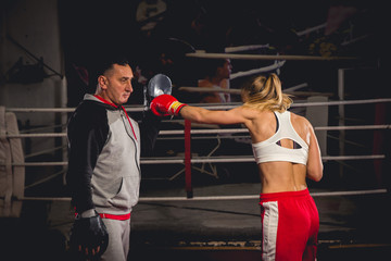 Women boxer hits mitts held by her trainer