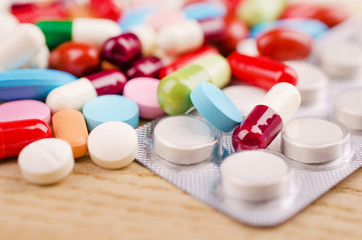 Multicolored Capsules and Pills Lying on a Wooden Surface. Closeup