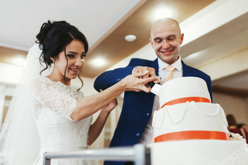 Look from below at lovely wedding couple cutting cake