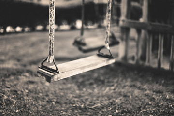 monochrome image empty swing at the playground in summer, horizo