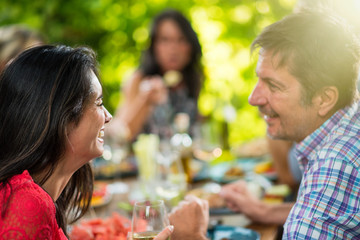 Back view, woman lunching with friends on a terrace table