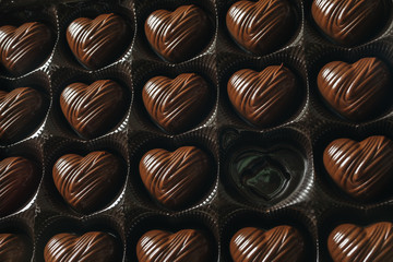 Box of heart-shaped chocolate, one candy empty