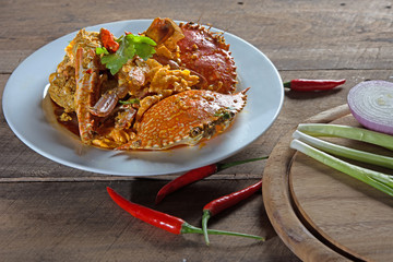 Crab curry in Thai infused red coconut curry sauce on wood background and Chopping Wood, selective focus