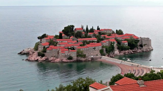 The Sveti Stefan island is connected to the mainland by a narrow isthmus. View from the same name city. The Adriatic sea, Montenegro, Europe
