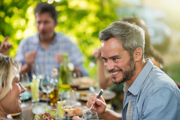A man lunching with friends on a terrace table