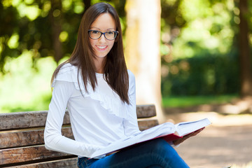 Obraz premium Young woman studying at the park