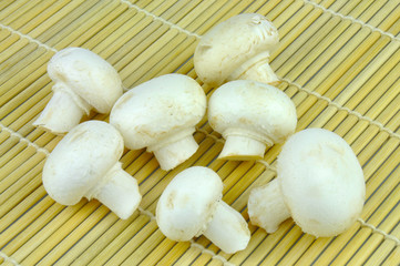 Button mushrooms on bamboo mat
