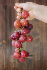 Woman hand holding bunch of grape.