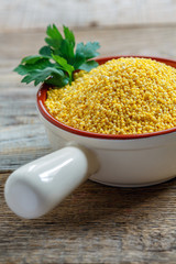 Organic millet and a sprig of parsley in the ceramic bowl.
