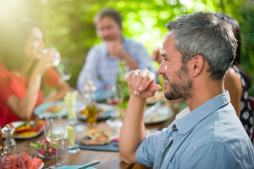 A man lunching with friends on a terrace table