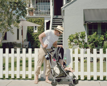 Father pushing baby in pushchair 