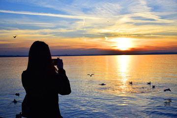 ragazza che fotografa il tramonto