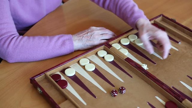 closeup of older woman playing backgammon
