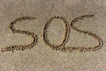 SOS - Inscription on the sand of tropical beach