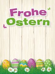 Frohe Ostern Grusskarte mit Ostereiern im Gras vor Holzwand