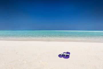 Fototapeta na wymiar Flip-flops on sand on tropical beach in Maldives