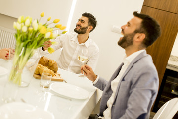 Two young men have dinner and toasting white wine