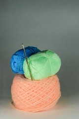Blue, green and pink balls of yarn.