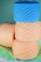 Three balls of pink yarn and blue ball of yarn.