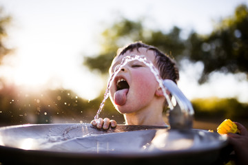 Boy drinking water from fountain 