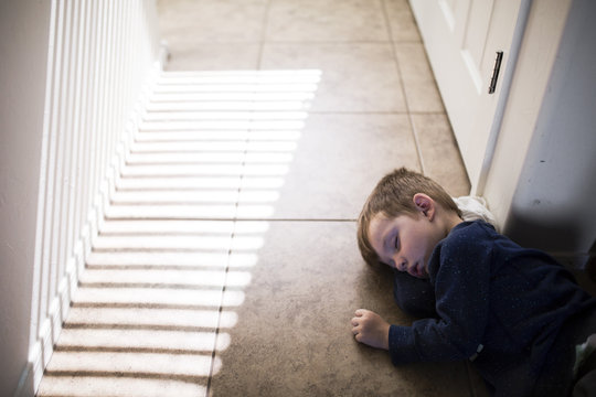 Boy Asleep On Floor With Sunlight 