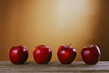 Cztery jabłka na drewnianym stole