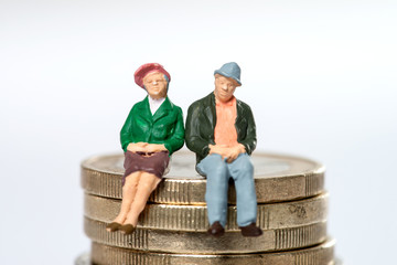 Rentner / älteres Ehepaar sitzt auf Euromünzen