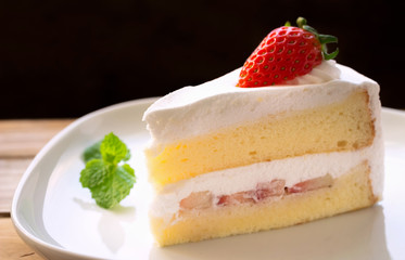 cake with cream and strawberries on a dark wood background. tinting.