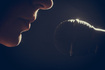 Fototapeta premium Kobieta śpiewa do mikrofonu