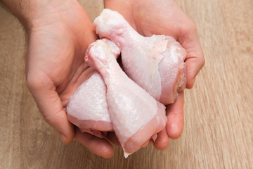 Man's hand holding a chicken meat in the kitchen. Cooking at home. Healthy eating and lifestyle.