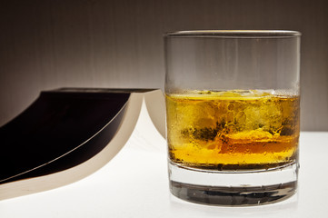 Glass of whiskey and a book - evening relax concept