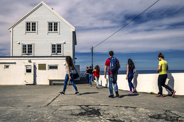 Group of people is walking around the lighthouse, Norway