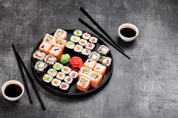 Sushi rolls set served in round plate, selective focus