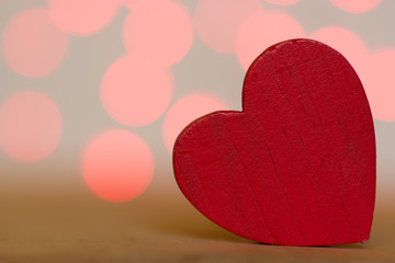 One red wooden heart on blurred background