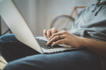 Working process concept, close-up of male hands typing text message on laptop keyboard, young male freelancer working from home on portable computer, man cheking email via laptop