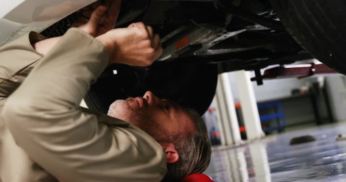 Mechanic servicing a automobile car in garage 4k