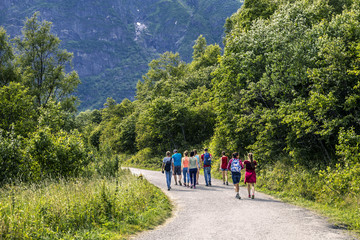 Group of young people walking along the road in national park, B