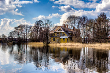 Obraz premium Landscape with old decaying and abandoned living house reflected in lake water.