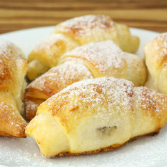 Homemade fresh bagels in white plate on wooden background.