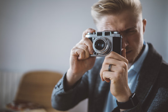 Young male photographer taking pictures via film camera, shooting - photography, creative, artist concept