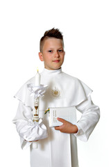 Młody chłopiec w stroju komunijnym na białym tle z książeczką i świecą. - obrazy, fototapety, plakaty