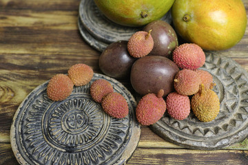 Lychees and Passion Fruit or Maracuya and Mango on wooden backgr