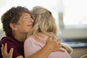 Smiling nurse hugging a relieved patient.
